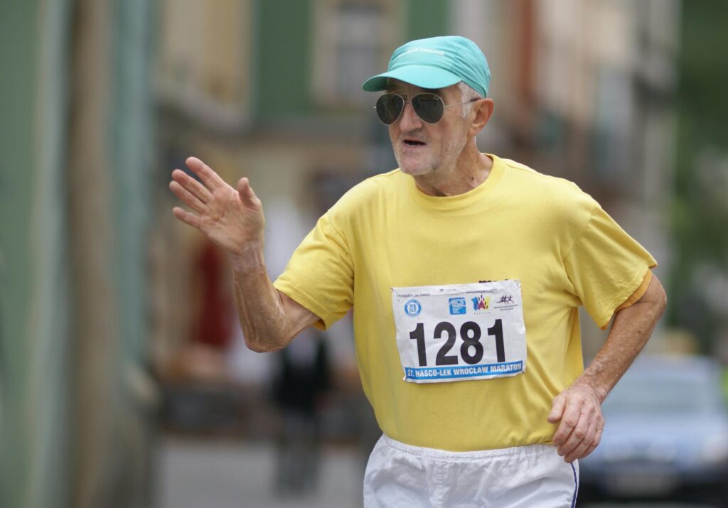 Elderly man participating in city marathon, showing determination.